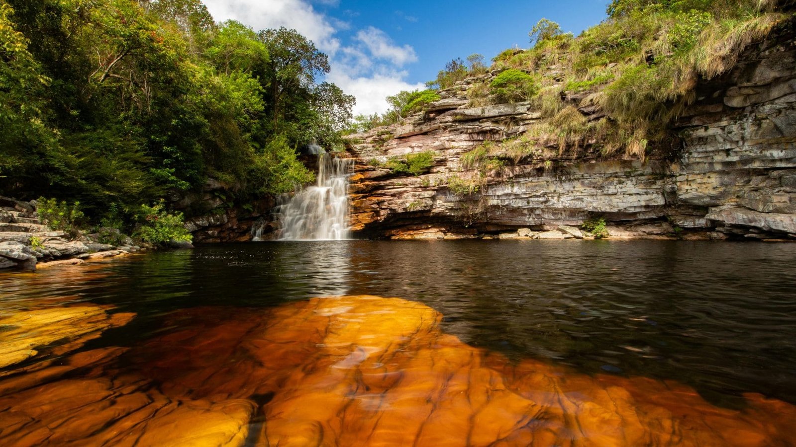 Sobre o Guia 1 Cachoeira cercada por vegetação nativa com poço de água entre formações rochosas