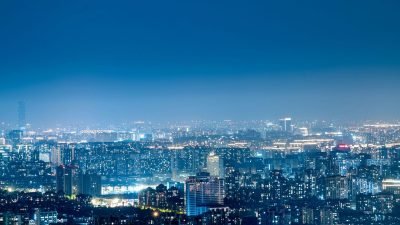 Cidade grande iluminada à noite com prédios e horizonte urbano