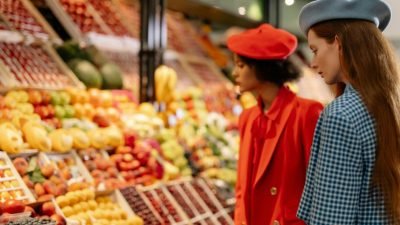 Clientes observando frutas e alimentos frescos em mercado local