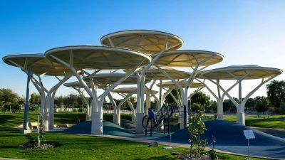 Parque urbano com área verde, brinquedos infantis e estrutura de lazer ao ar livre