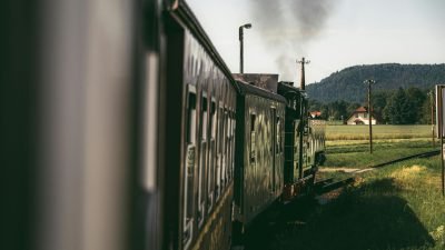 Trem turístico ilustrativo em área rural, representando passeio ferroviário histórico